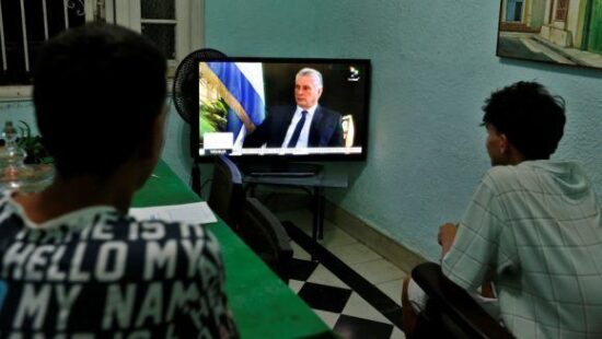 Dos jóvenes ven la entrevista al presidente cubano, Miguel Diaz-Canel, de la cadena de televisión TeleSur, en La Habana. Foto: EFE/Ernesto Mastrascusa.