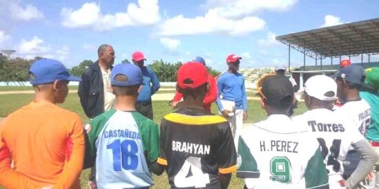 El peloterito trinitario Daniel Castañeda, con el número 18 en su uniforme, junto a los demás miembros del equipo Cuba, escuchan los consejos de la gloria deportiva Antonio Muñoz.