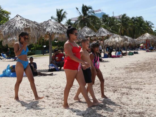 Para el disfrute, todos abrazan el verano en la playa.