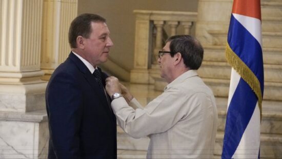 El ministro de Relaciones Exteriores Bruno Rodríguez Parrilla coloca la Medalla de la Amistad a Andrei Guskov, embajador de Rusia en Cuba. Foto: @BrunoRguezP/Twitter.