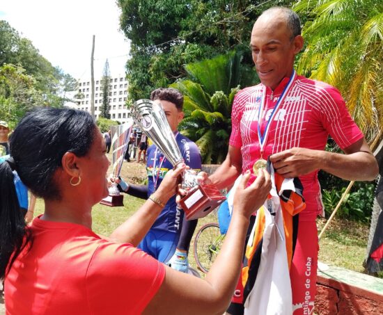 Laidalí Santana carrero, directora del INDER en Sancti Spíritus, le entrega al santiaguero Pedro Portuondo la camiseta de líder de la Vuelta.