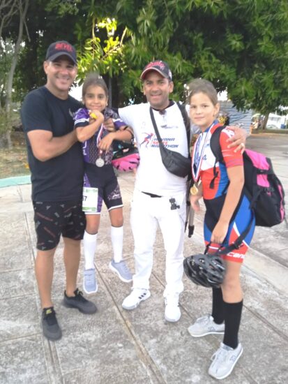 Los entrenadores trinitarios Yoelvis Pereira y Emil Bravo, junto a las dos medallistas.