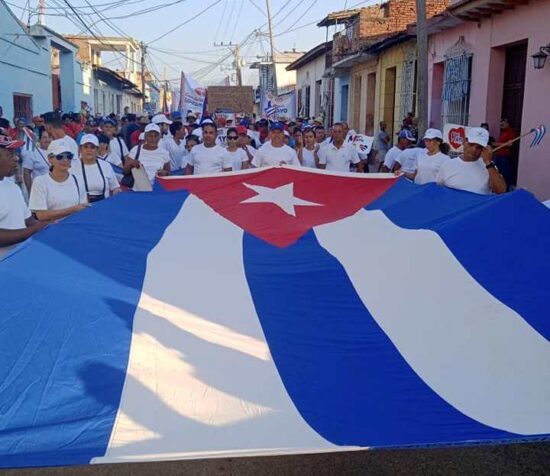 Lo mismo en manos jóvenes que en curtidos combatientes de la Revolución Cubana, nuestra Enseña Nacional. Foto: Facebook.
