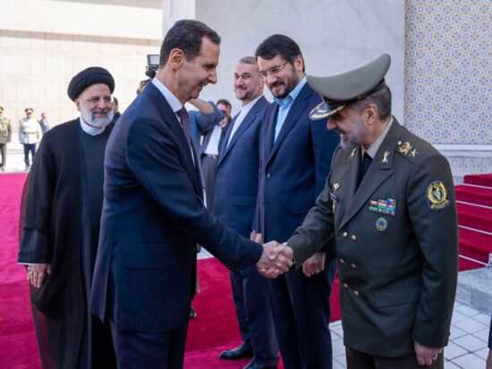 El presidente sirio Bashar Al-Assad saluda a la delegación que acompaña a su homólogo iraní, Ibrahim Raisi, en Damasco.