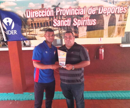 El intendete jailer Rabelo le entrega la placa de reconocimiento al trinitario Rodolexis Moreno, segundo mejor bateador de los Gallos con promedio de 330.